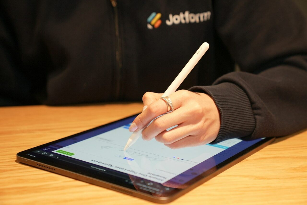 a person writing on a tablet with a pen